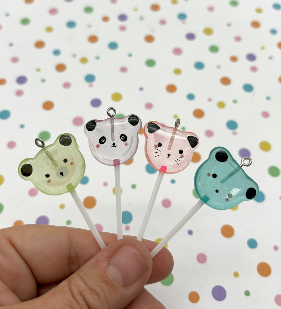 a hand holding four small animal shaped toothpicks