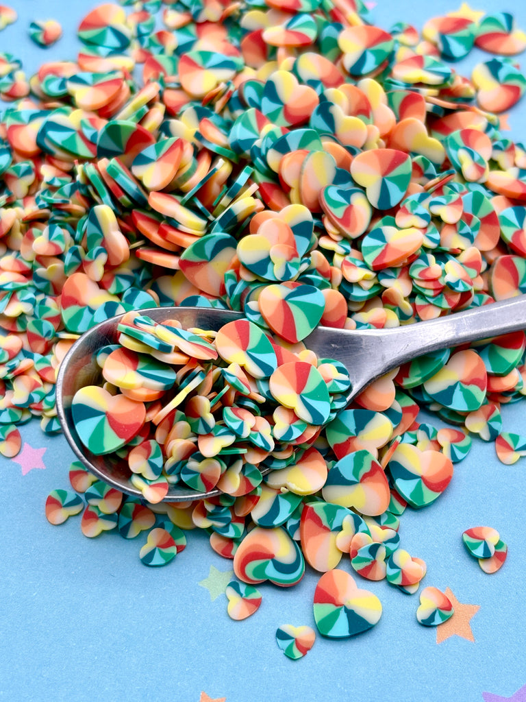 a spoon full of colorful confetti on a blue surface