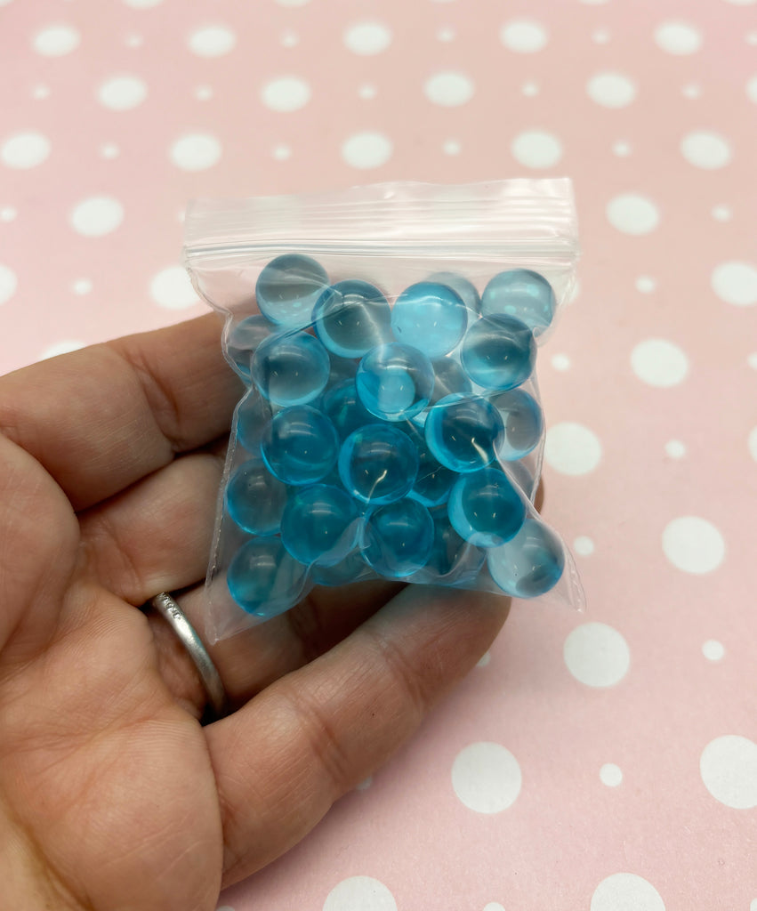 a hand holding a bag of blue and white buttons