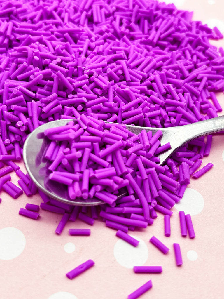a spoon full of purple sprinkles on a table