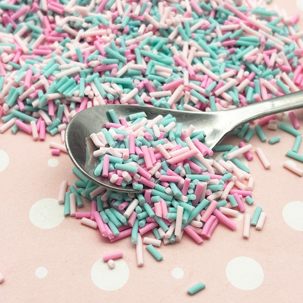 a spoon full of sprinkles sitting on top of a table