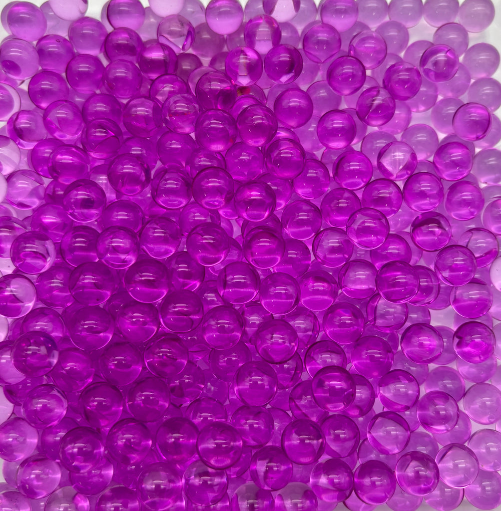 a pile of purple plastic balls sitting on top of a table