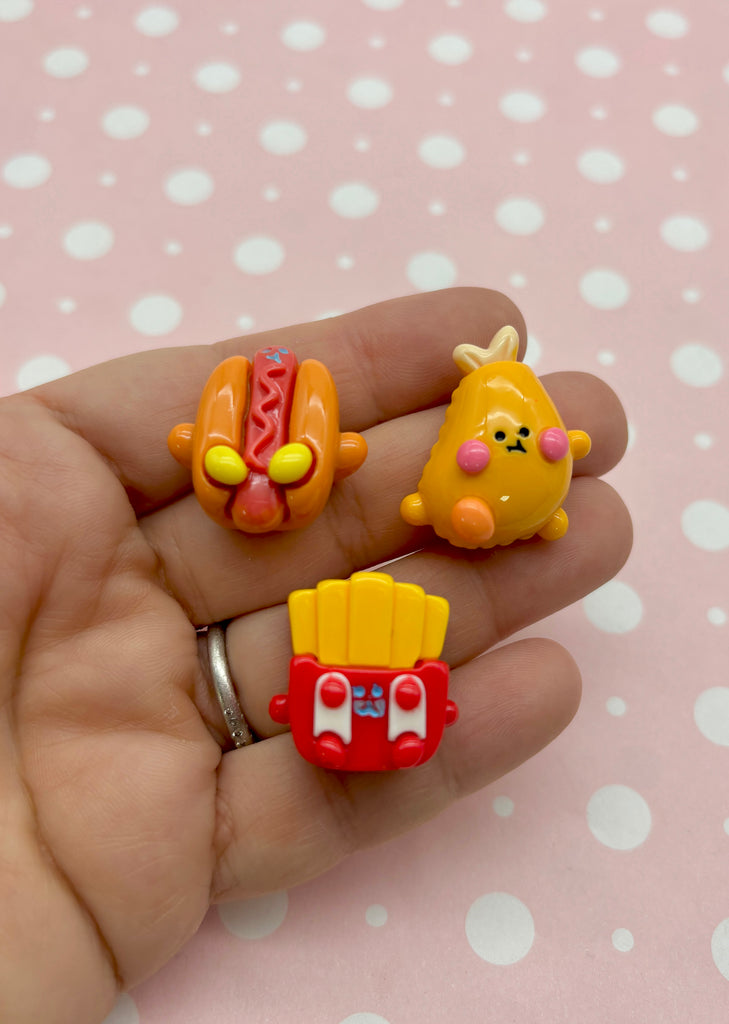 a hand holding three small toys in it's palm