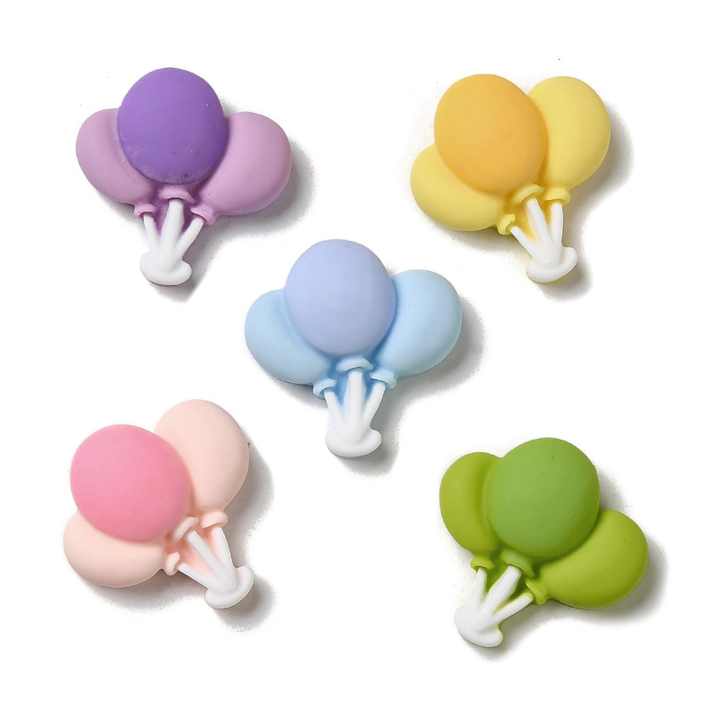 a group of four different colored balloons on a white surface