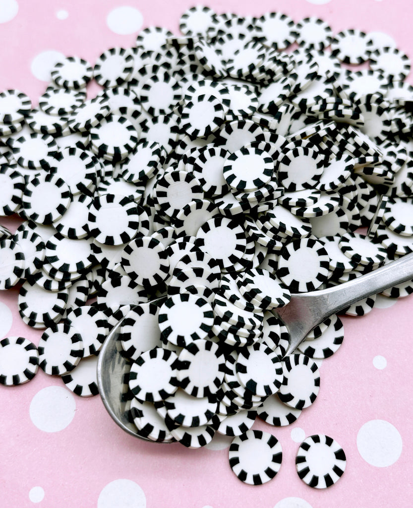a pile of black and white confetti sprinkles with a spoon