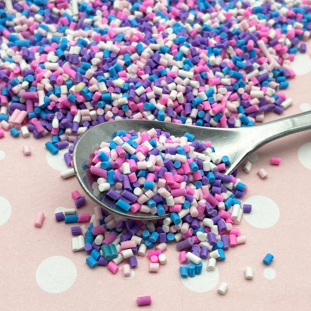 a spoon filled with sprinkles on top of a table
