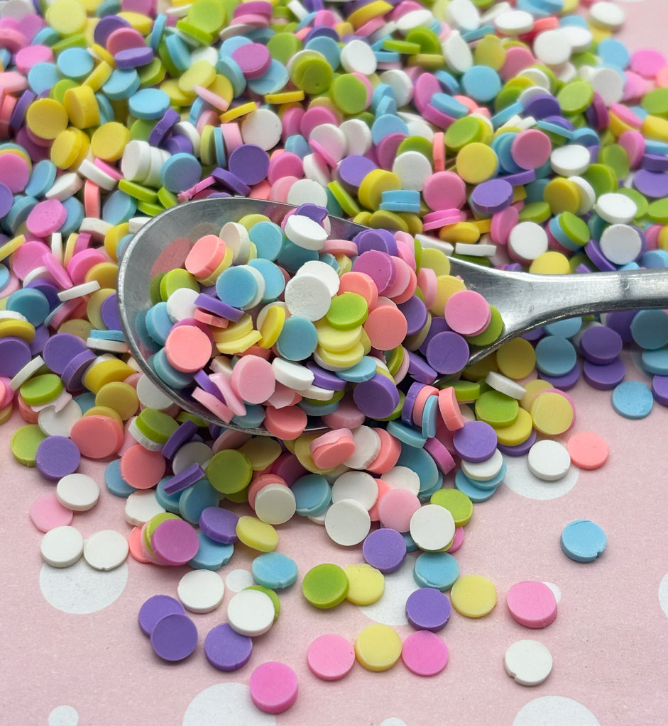a spoon full of colorful confetti on a table