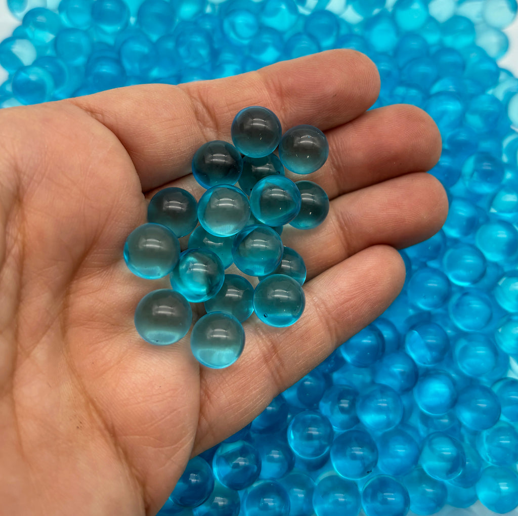 a hand holding a bunch of blue glass beads