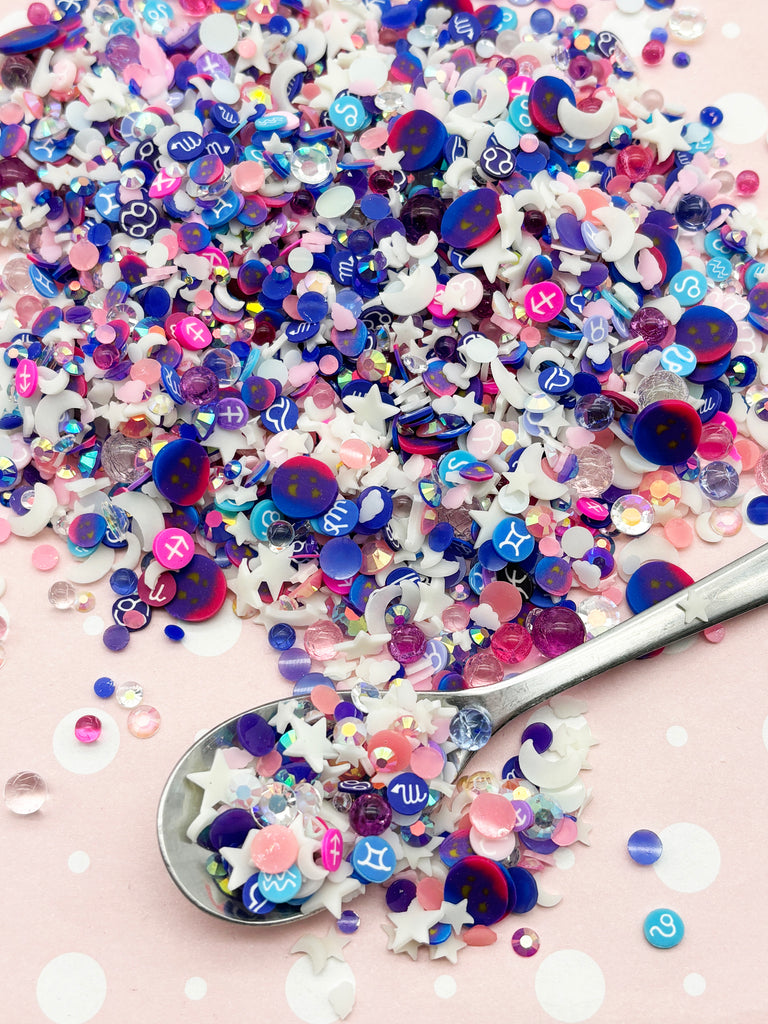 a spoon full of colorful confetti on a pink background