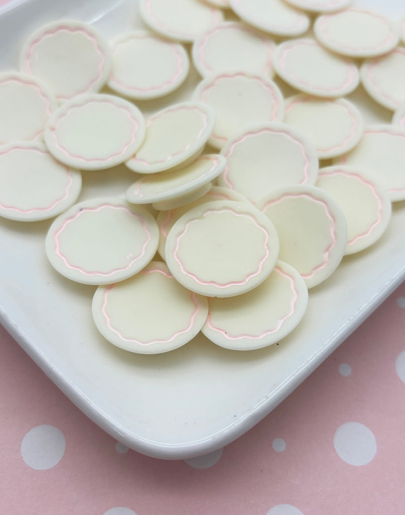 a white plate topped with lots of white and pink cookies