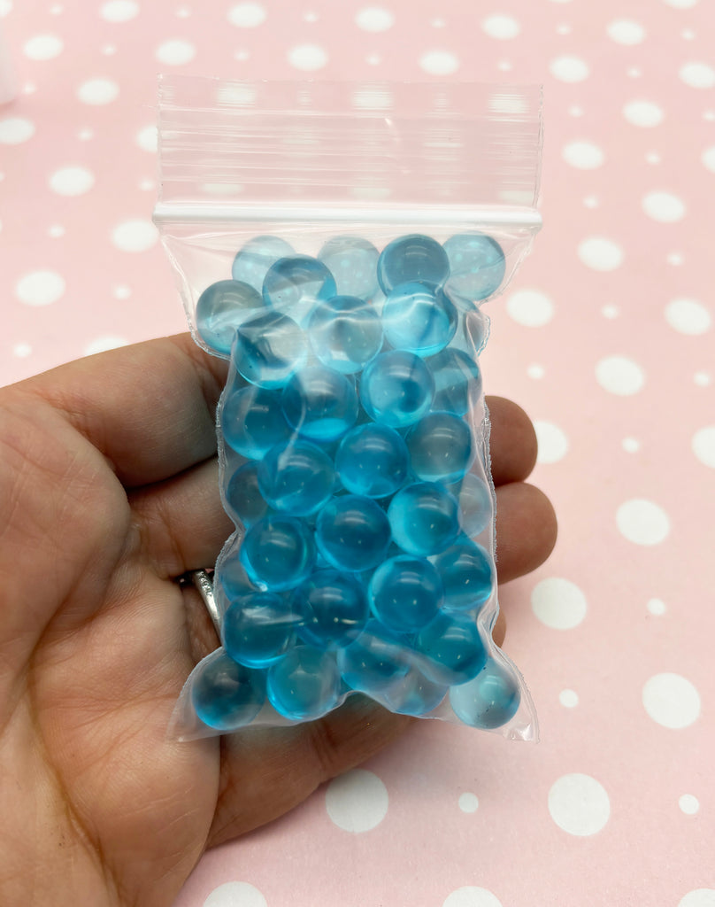 a hand holding a bag of blue candies
