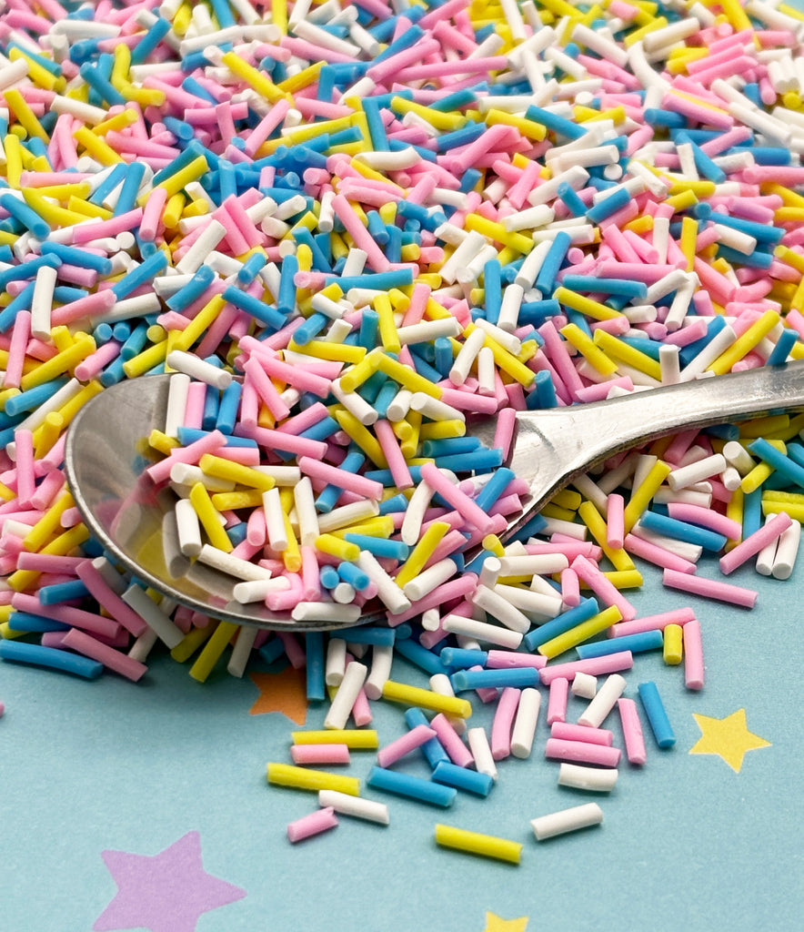 a pile of sprinkles and a spoon on a table