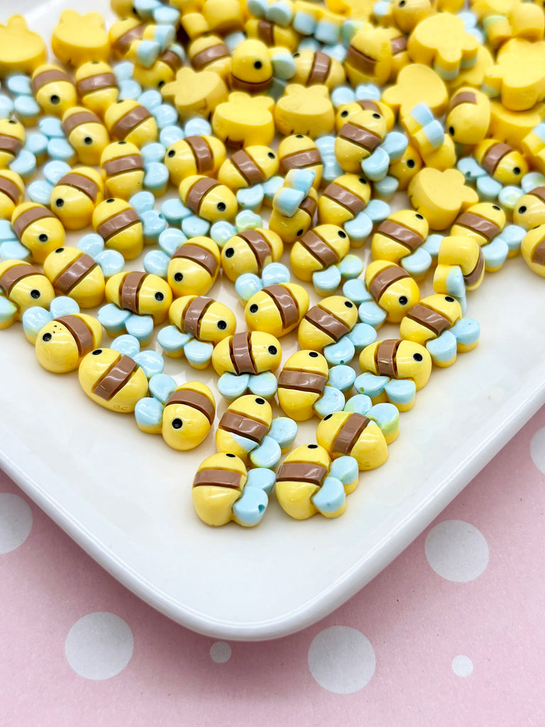 a white plate topped with lots of yellow and blue beads