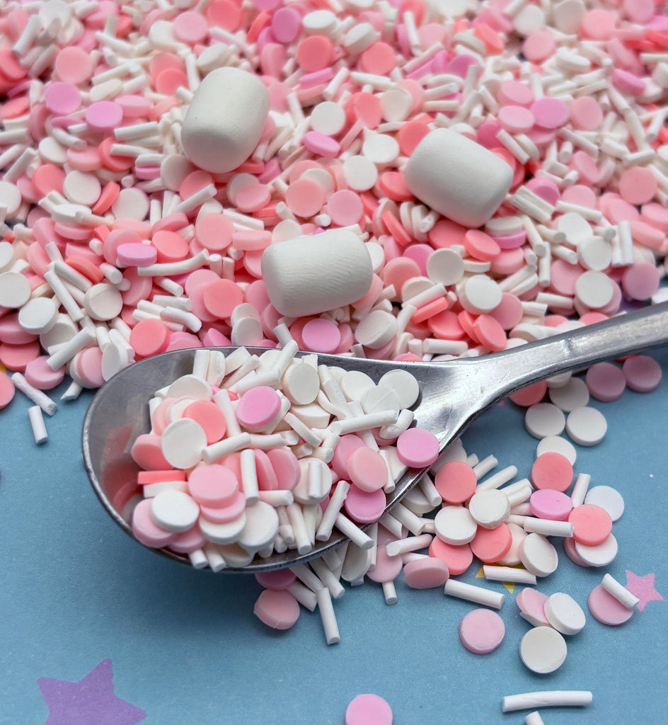 a spoon full of pink and white sprinkles