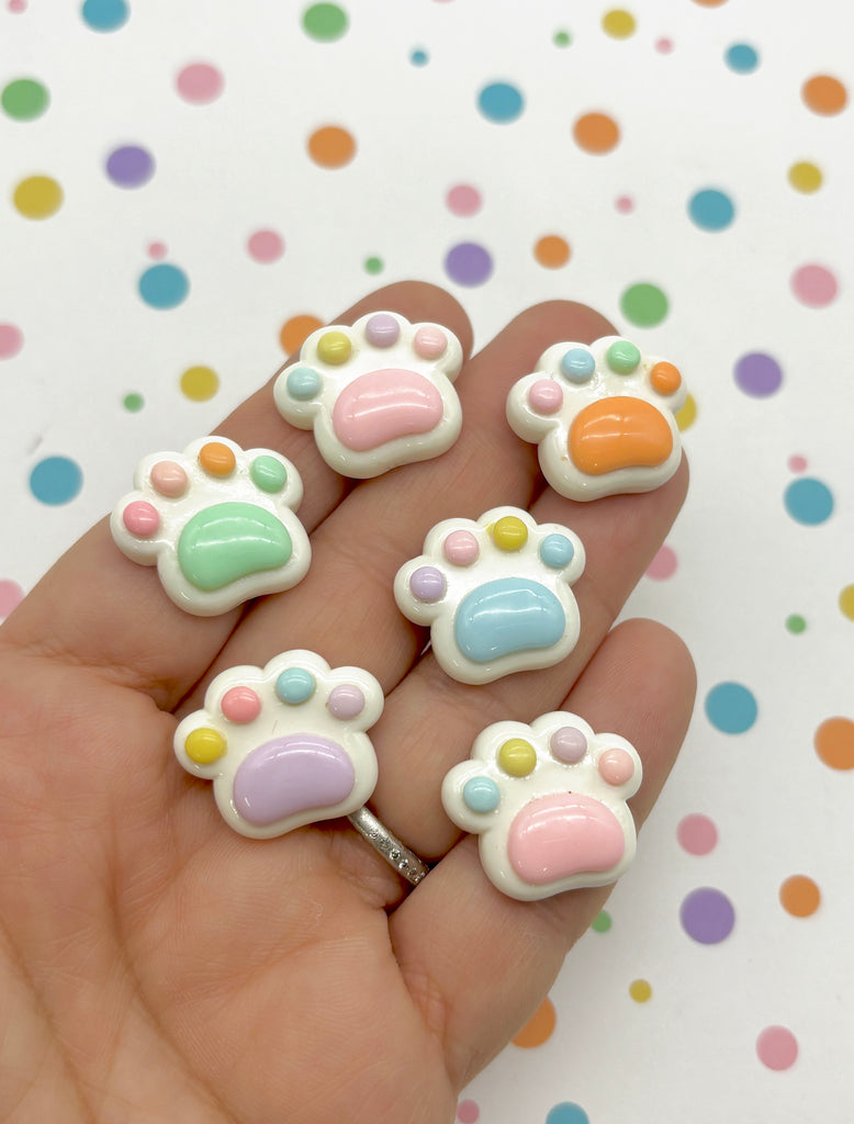 a person is holding five small animal shaped beads