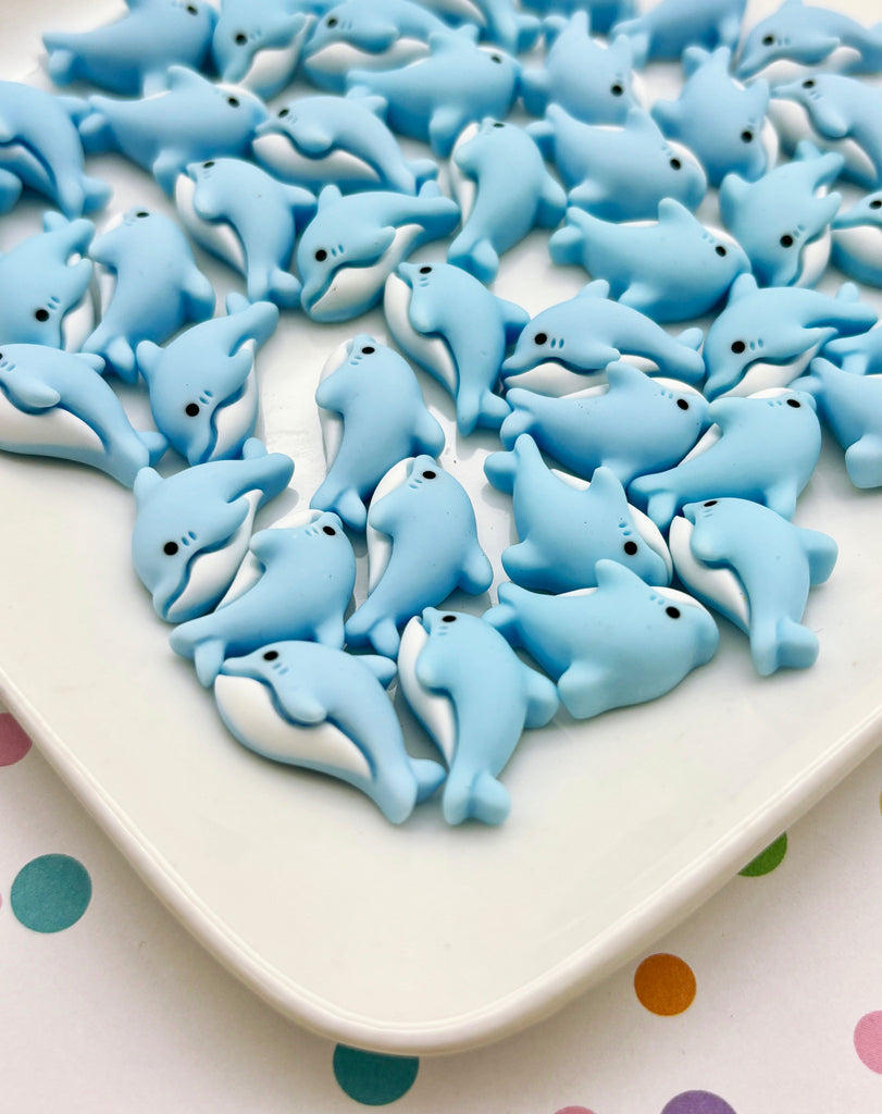 a white plate topped with lots of blue dolphins