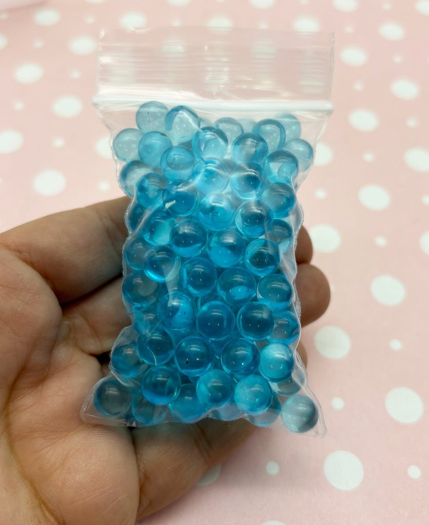 a hand holding a bag of blue beads