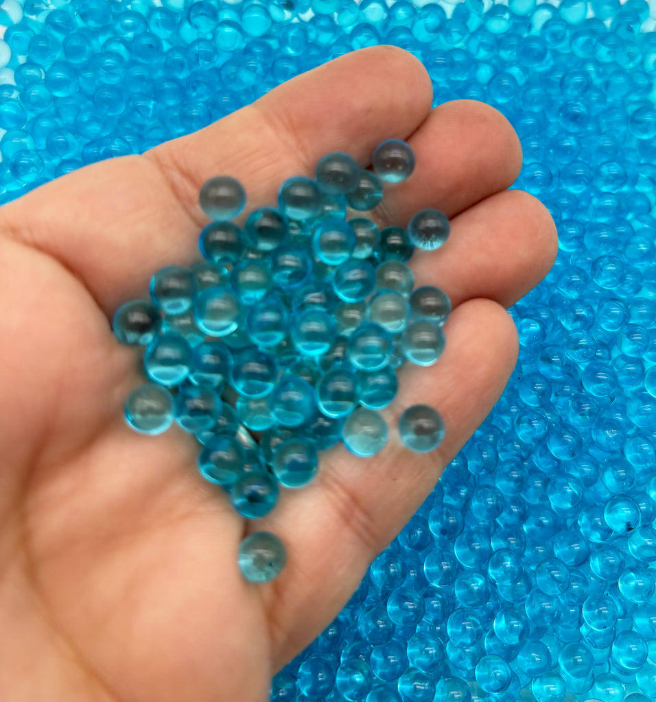 a hand holding a bunch of blue beads