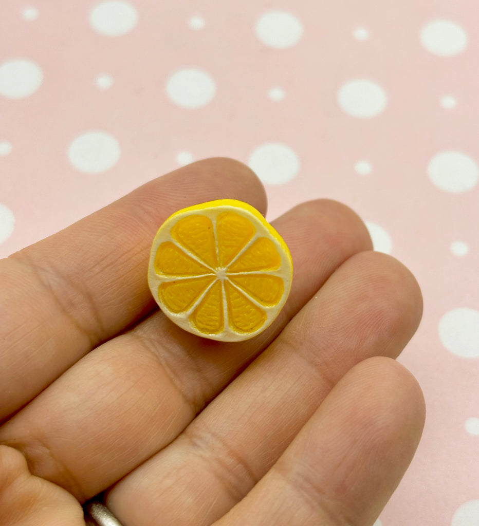 a person holding a tiny orange slice in their hand