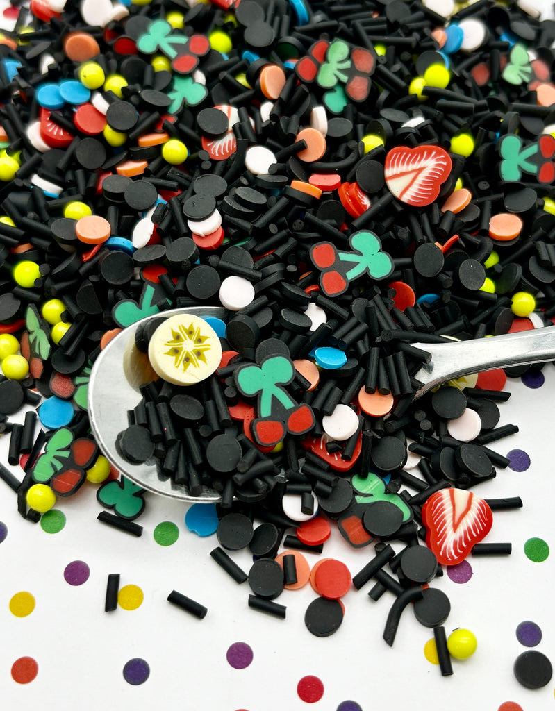 a spoon full of black sprinkles with a button on it