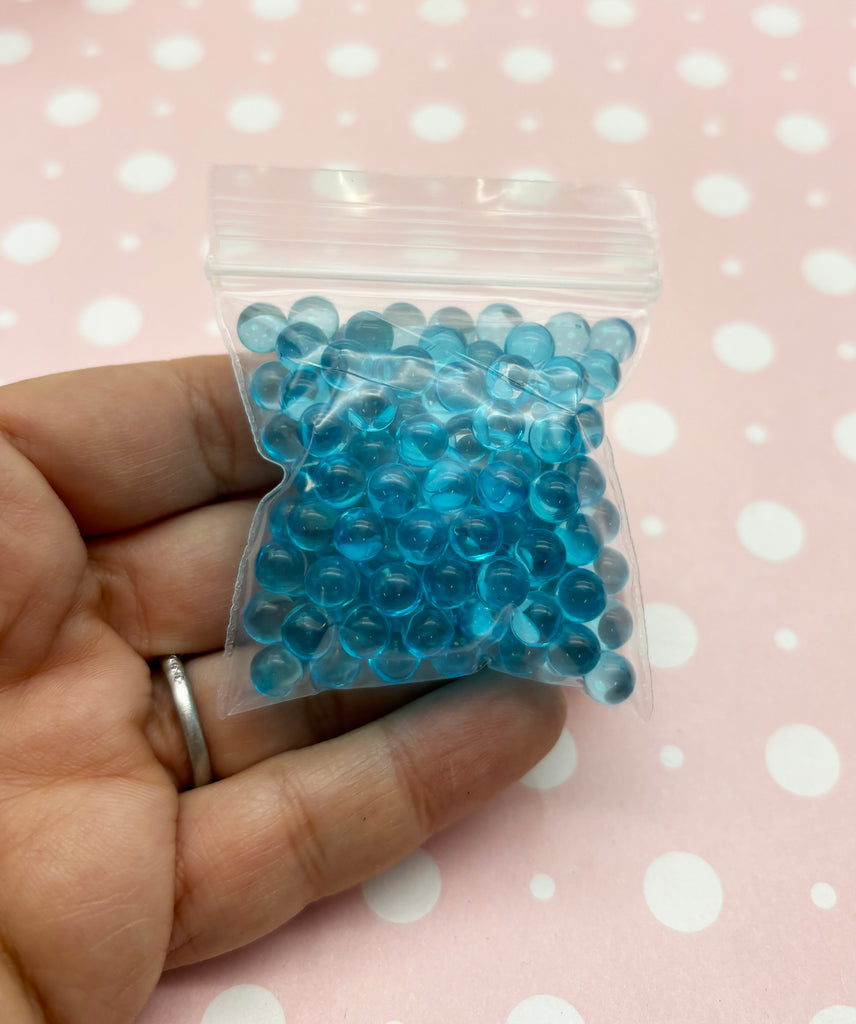 a person holding a bag of blue beads