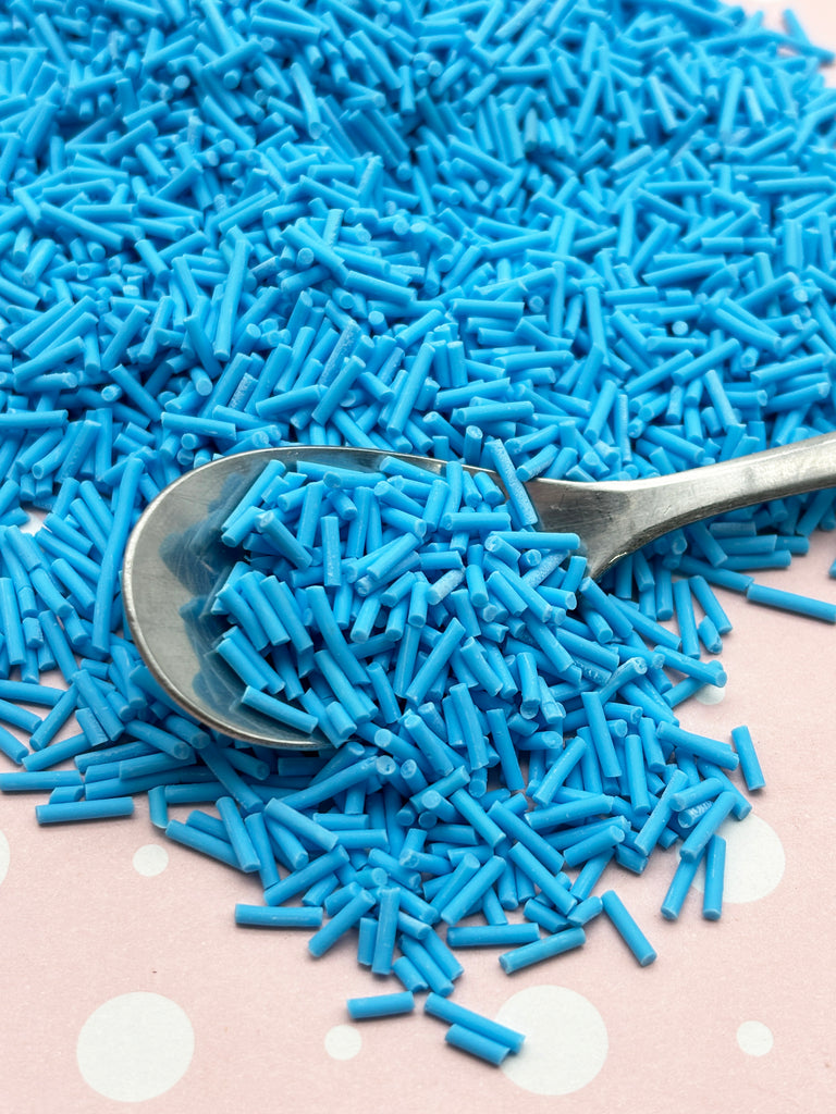 a spoon full of blue sprinkles on a table