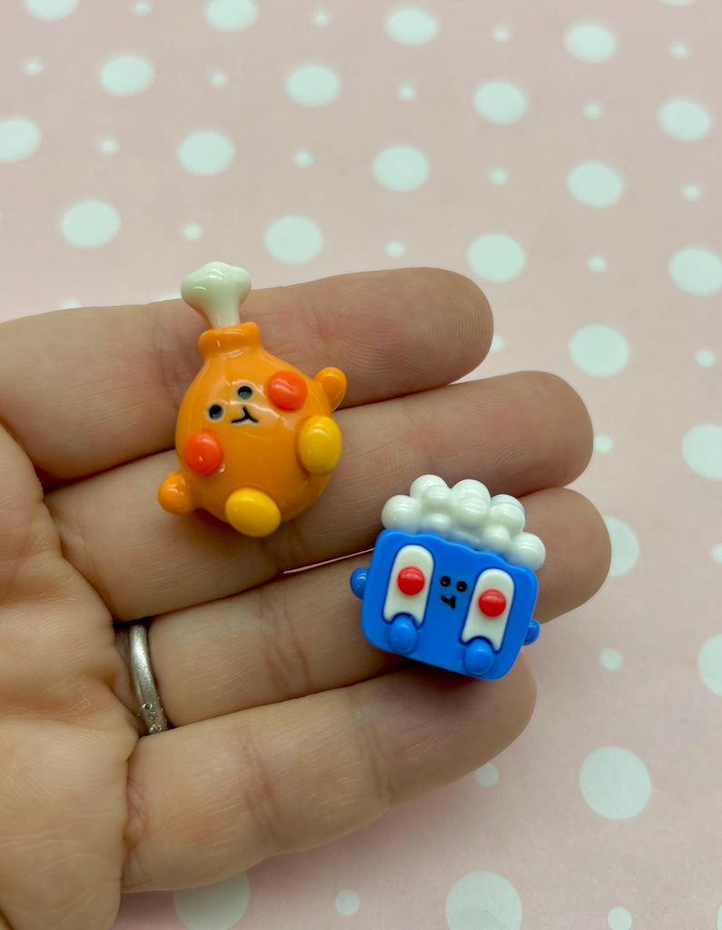 a hand holding two small toys in it's palm