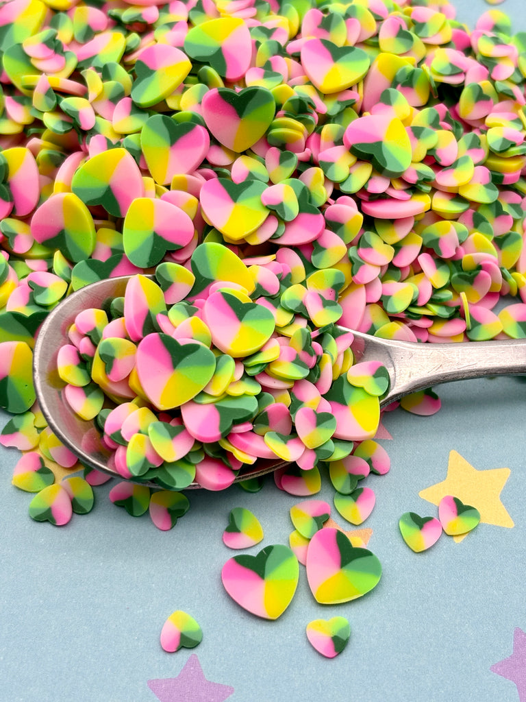 a spoon full of pink, green and yellow confetti