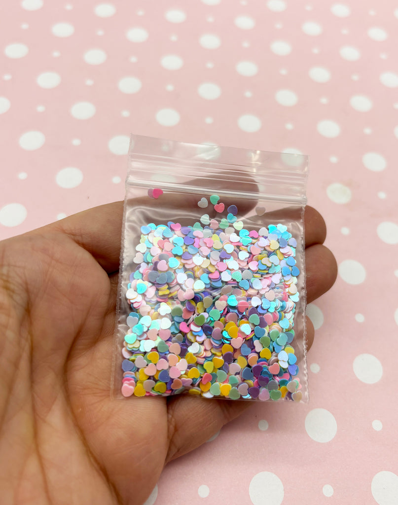 a hand holding a small bag of colorful sprinkles