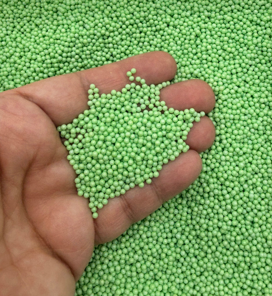a hand holding a handful of green peas