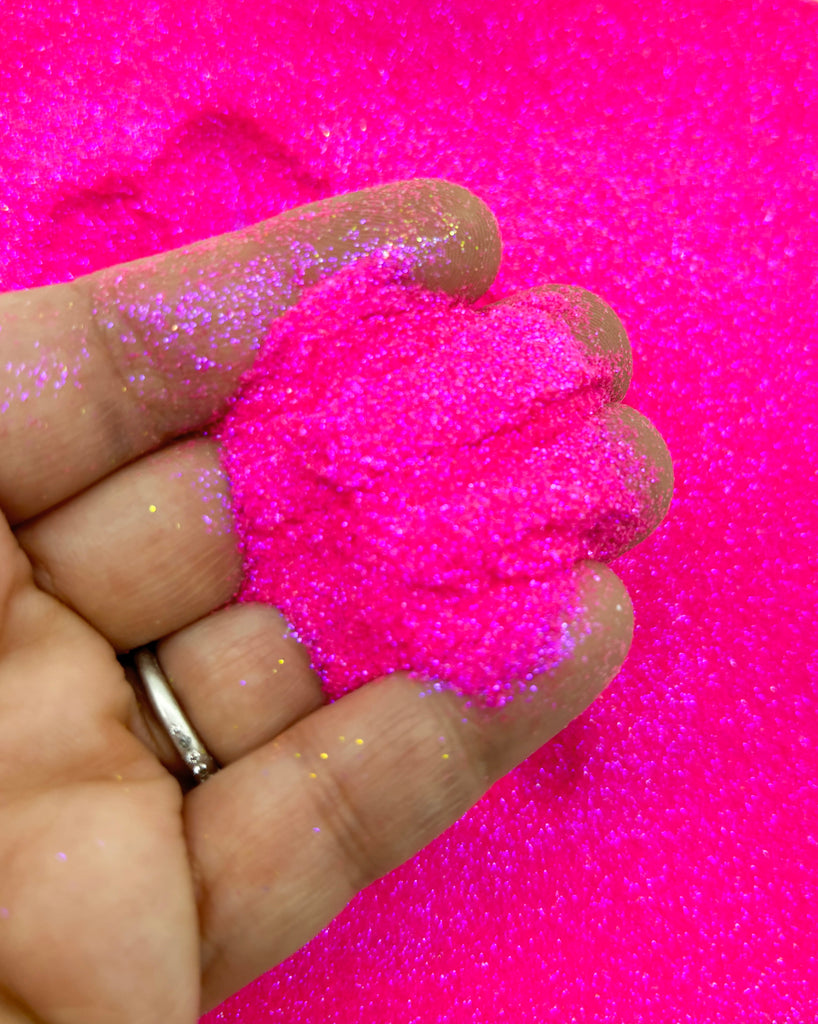 a person is holding a pink substance in their hand