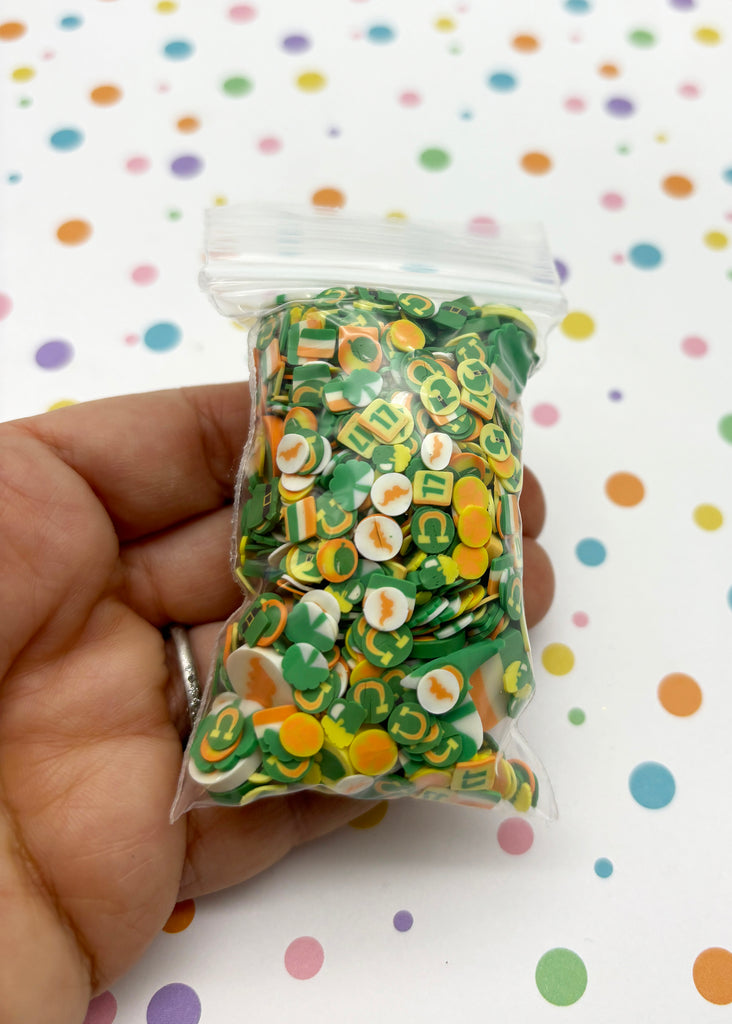 a hand holding a bag of green and yellow buttons