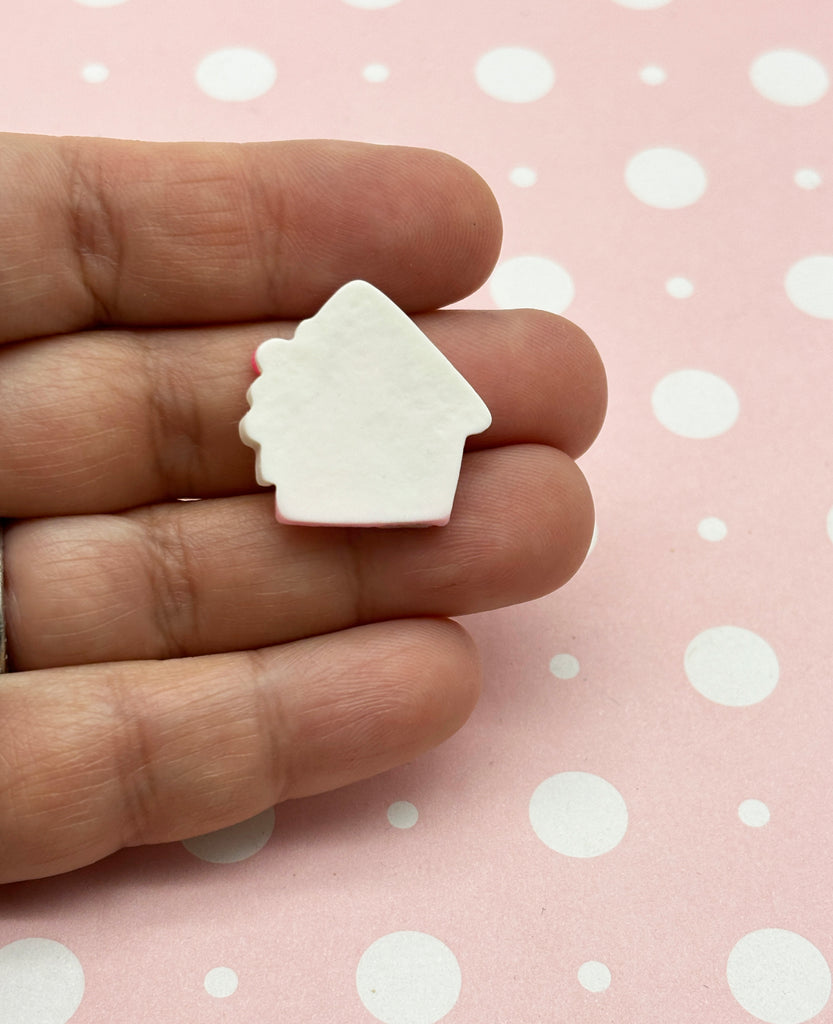 a hand holding a small white house shaped object