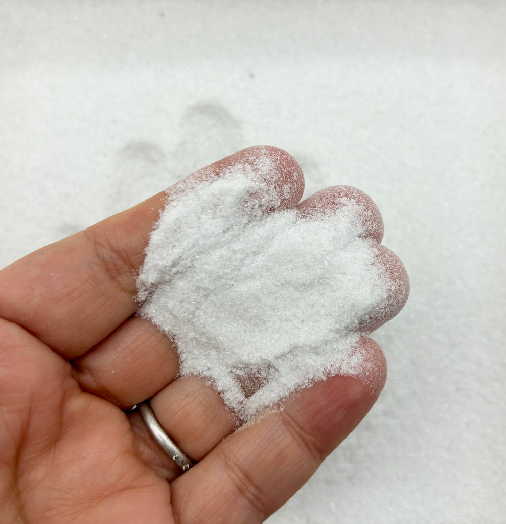 a hand holding a handful of powdered sugar