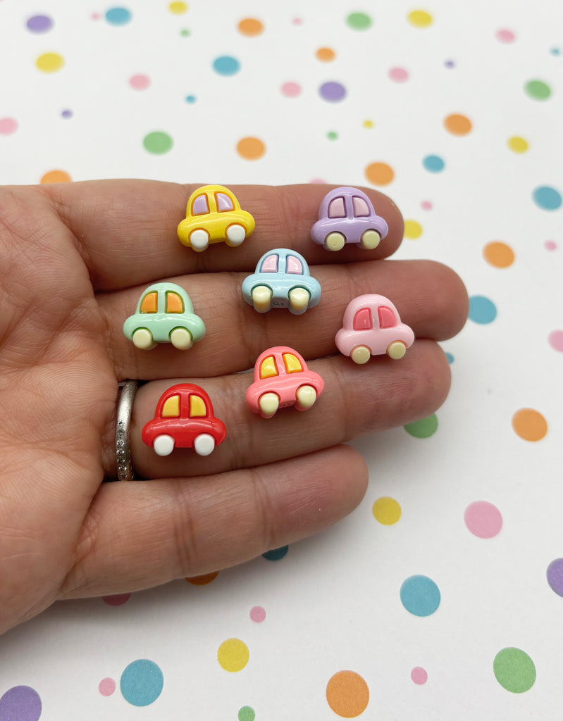 a person's hand holding five tiny toy cars