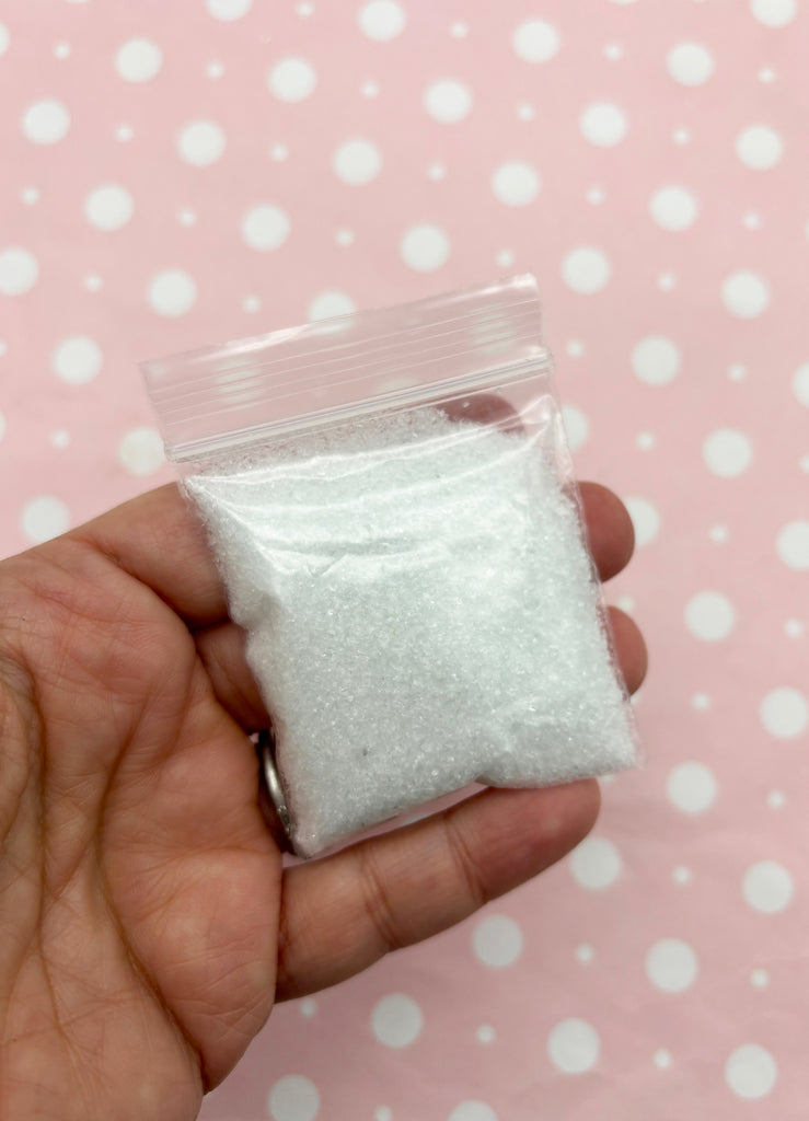 a hand holding a small bag of sugar
