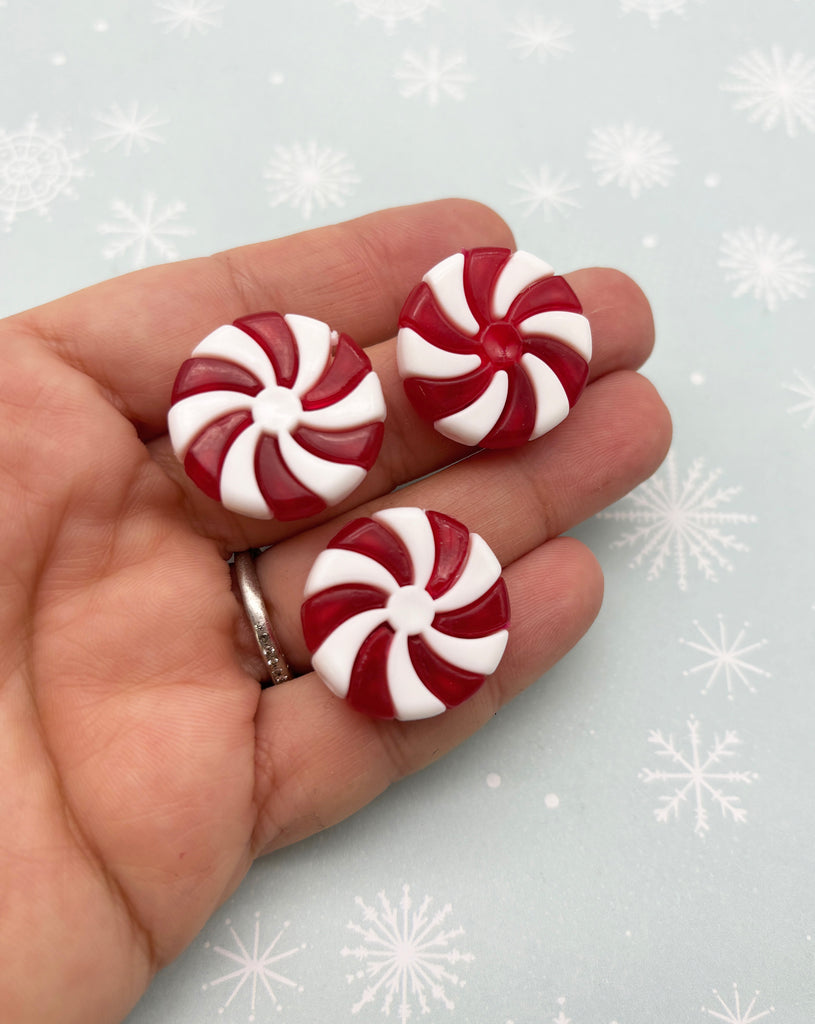 a hand holding two red and white candy canes