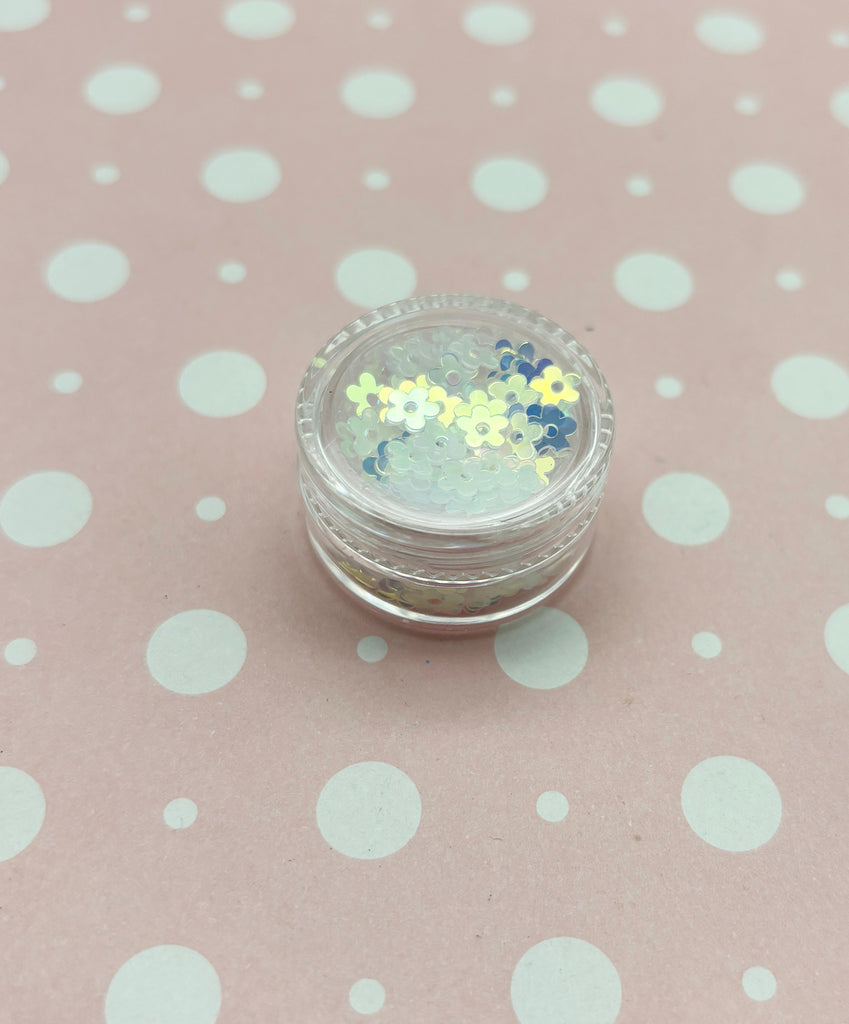 a small jar of glitter sitting on top of a polka dot tablecloth