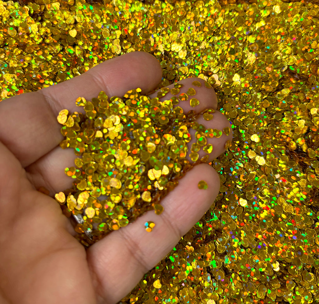 a hand holding a handful of gold glitter