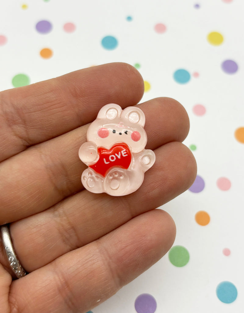 a small teddy bear holding a heart in its hand