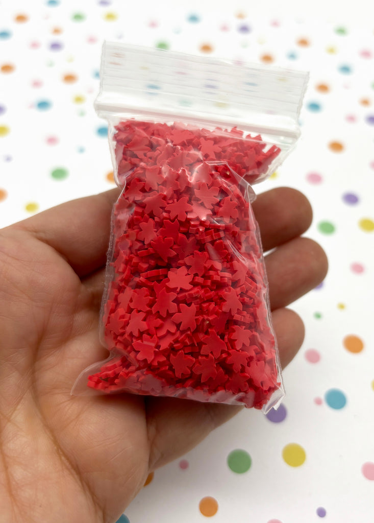 a hand holding a bag of red sprinkles