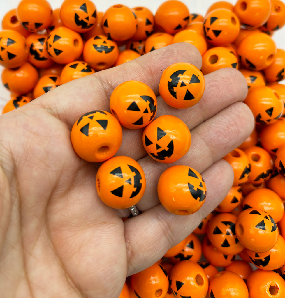 a hand holding a bunch of orange beads