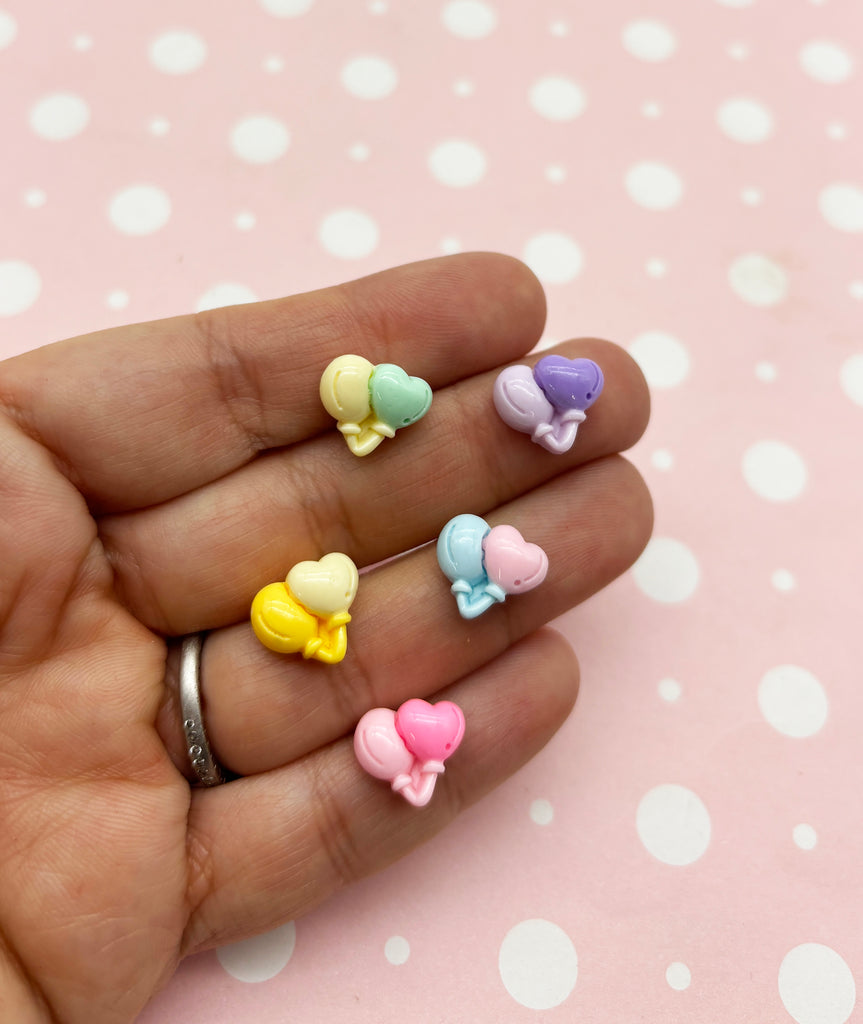a person's hand holding five small bows