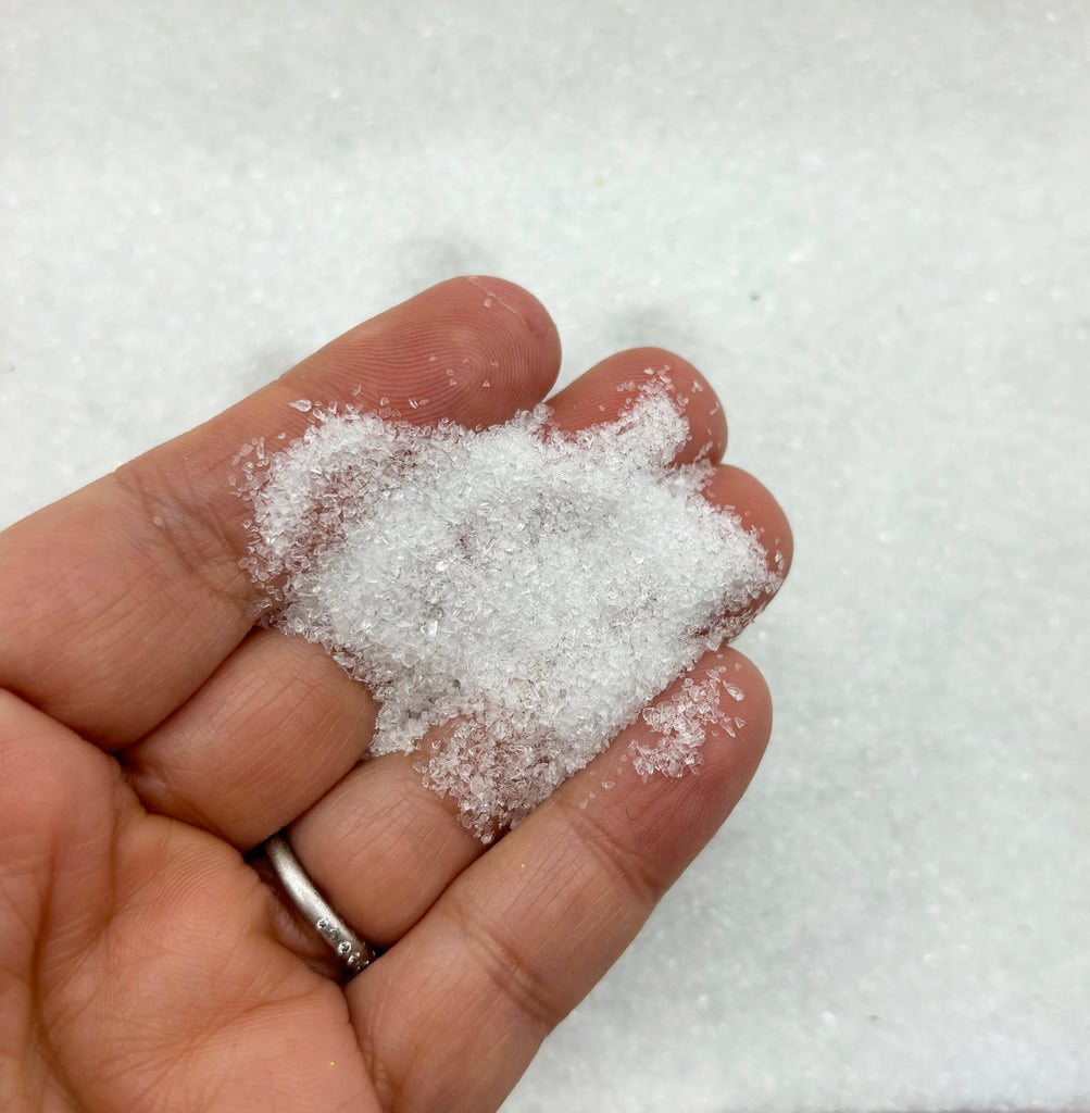 a hand holding a small pile of white sugar