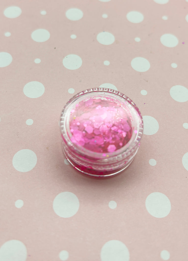 a pink and white ring sitting on top of a polka dot tablecloth