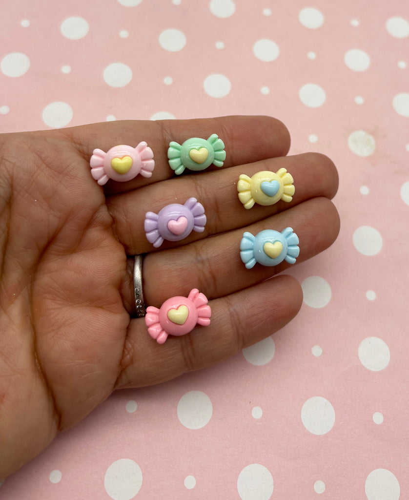 a person's hand with four different colored bows on it