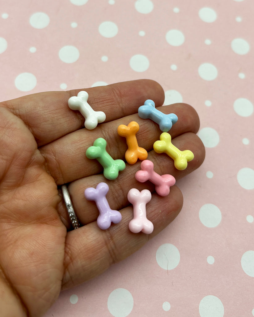 a person's hand holding a small assortment of small toy bones