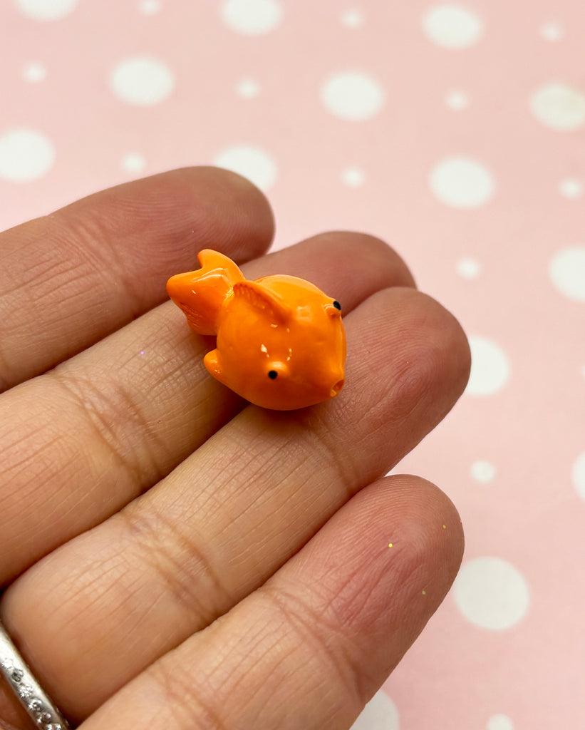a tiny orange animal sitting on top of a persons hand