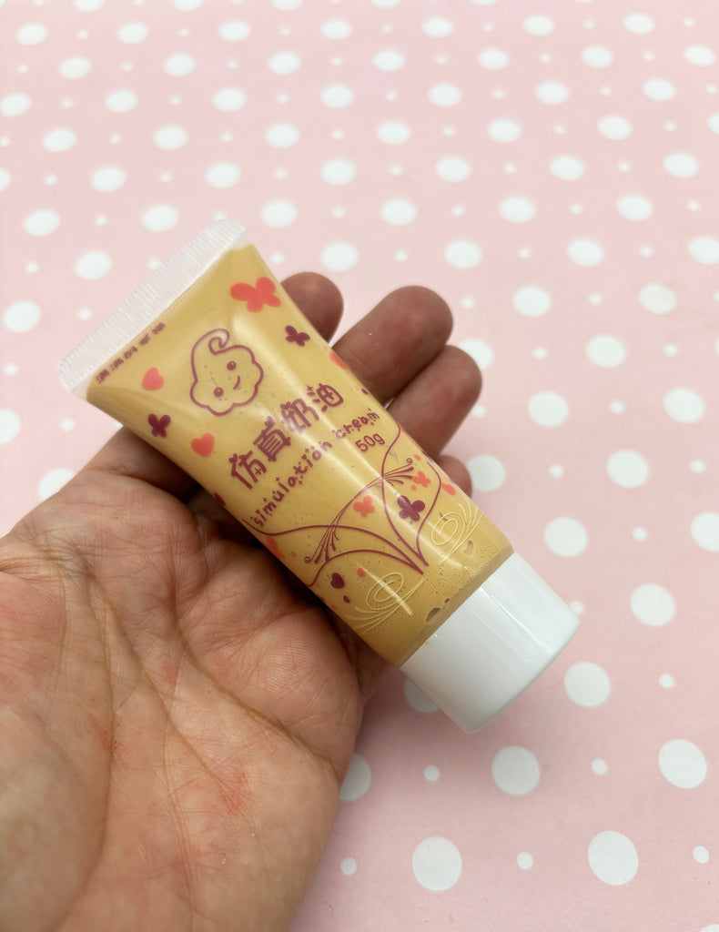a hand holding a tube of toothpaste on a pink background