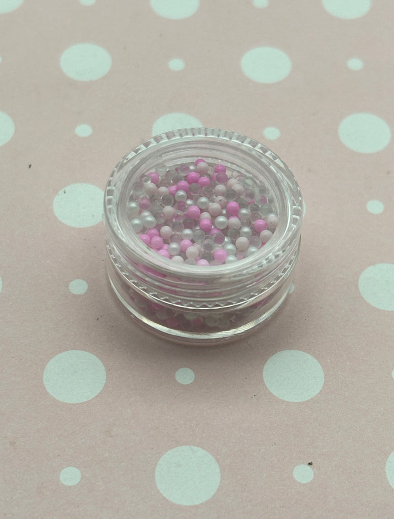 a small jar of beads sitting on a polka dot tablecloth